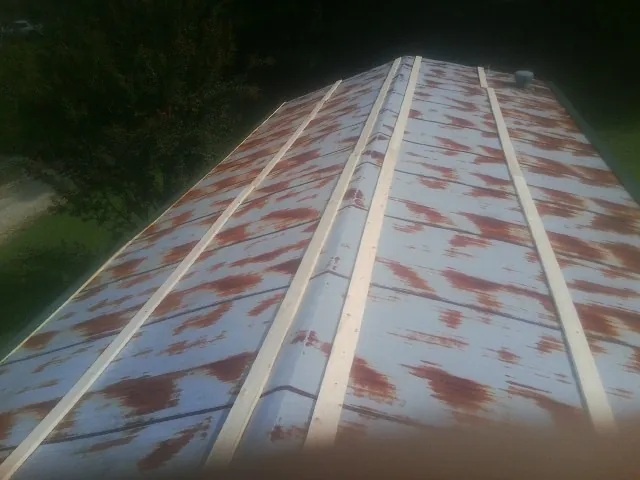 Rusted metal roof panels with new wood purlins before replacement — Storm Damage Roof Repair in Baltimore by Roofing Brothers