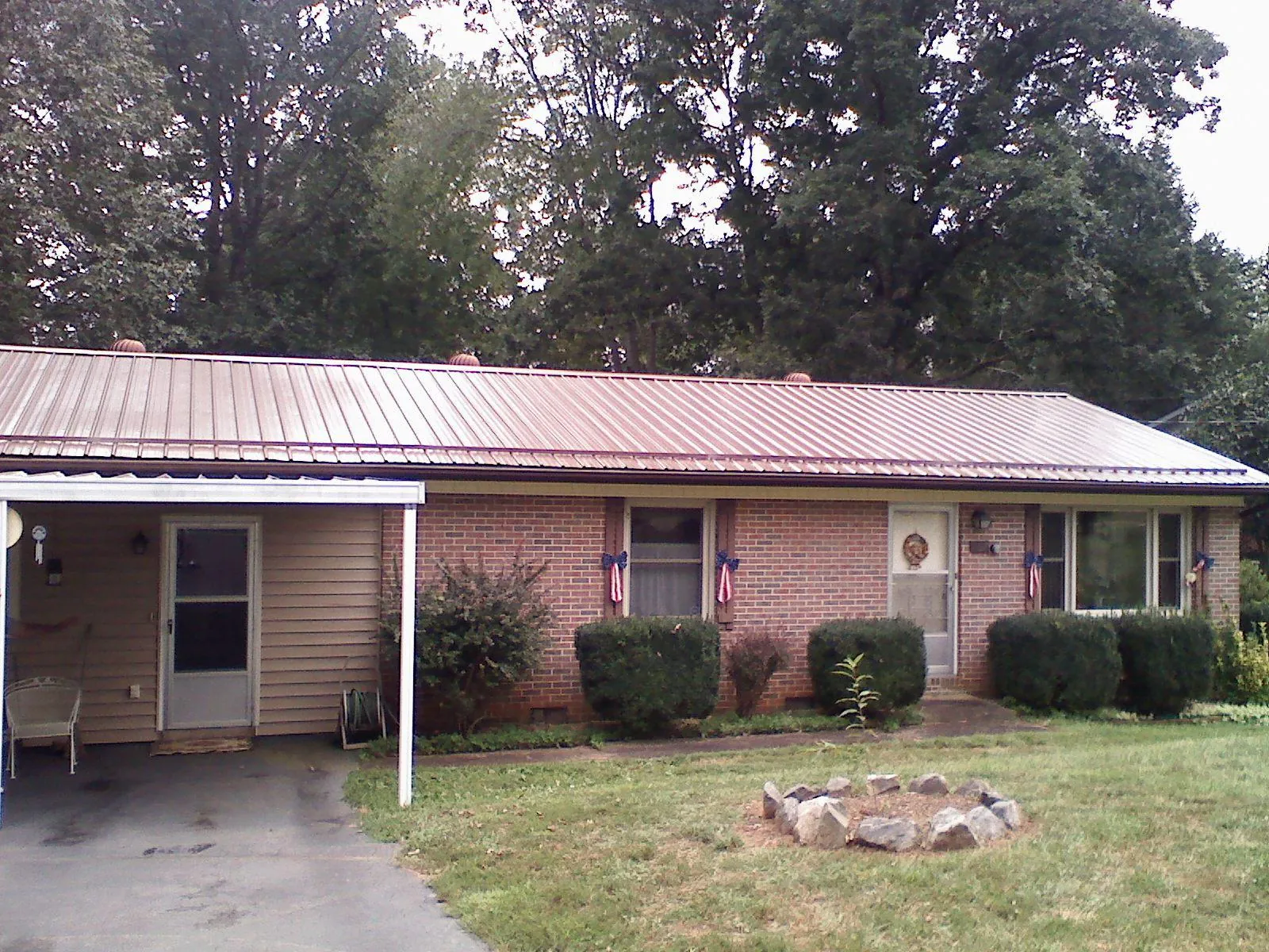 Bronze metal roof and carport on a brick ranch home — Roof Repair work by our crew in Baltimore